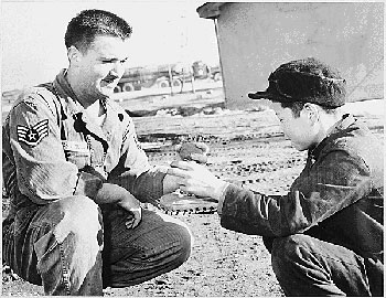 Sgt. James W. Black of the Fifth Air Force's 49th Fighter Bomber Wing instructs a Korean youth, Kim Pak Soon, in the fundamentals of baseball during the Korean War, 1951. (National Archives)